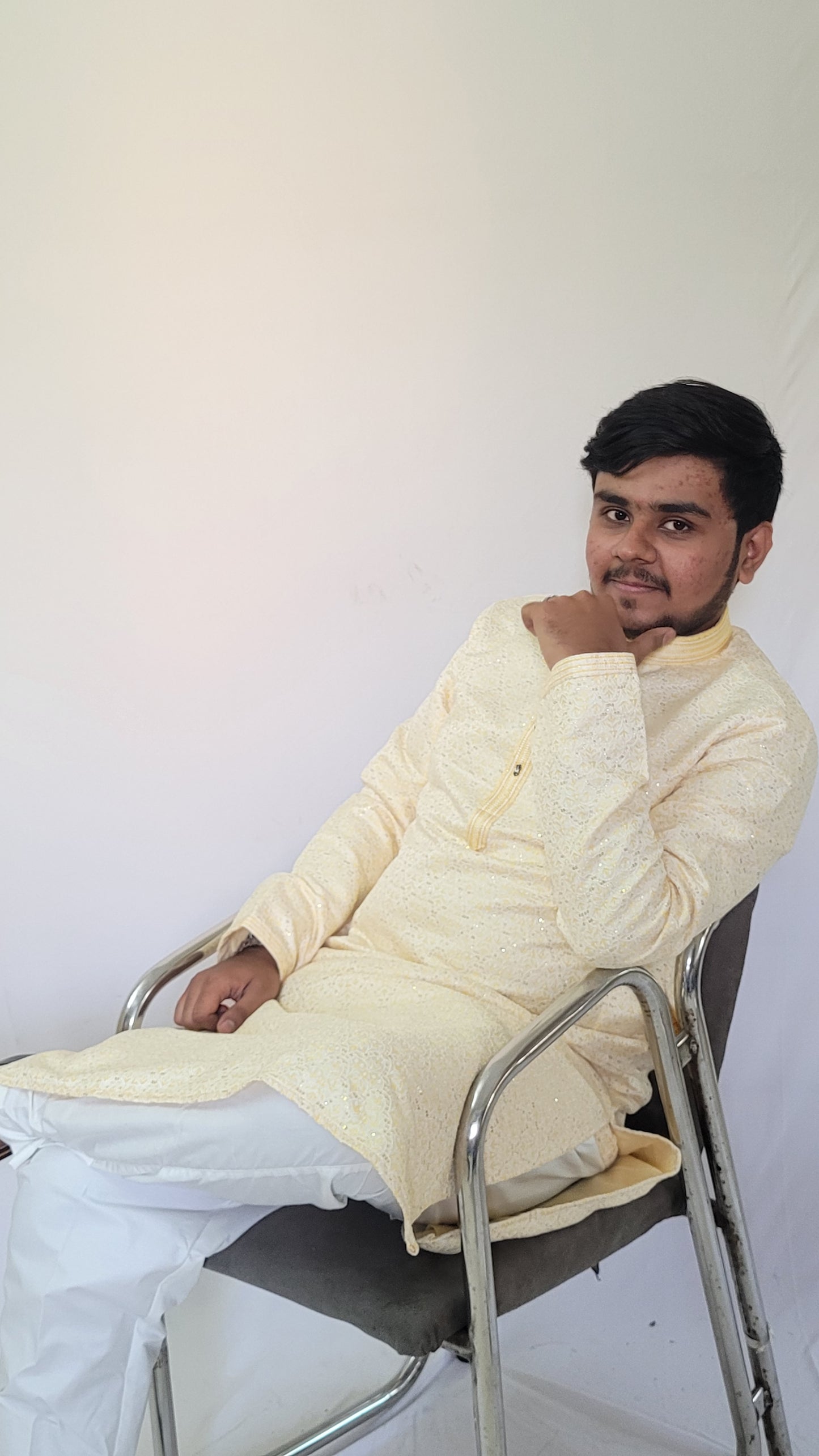 Left angle seated view of men’s ivory sequin kurta – subtle shimmer and jacquard texture